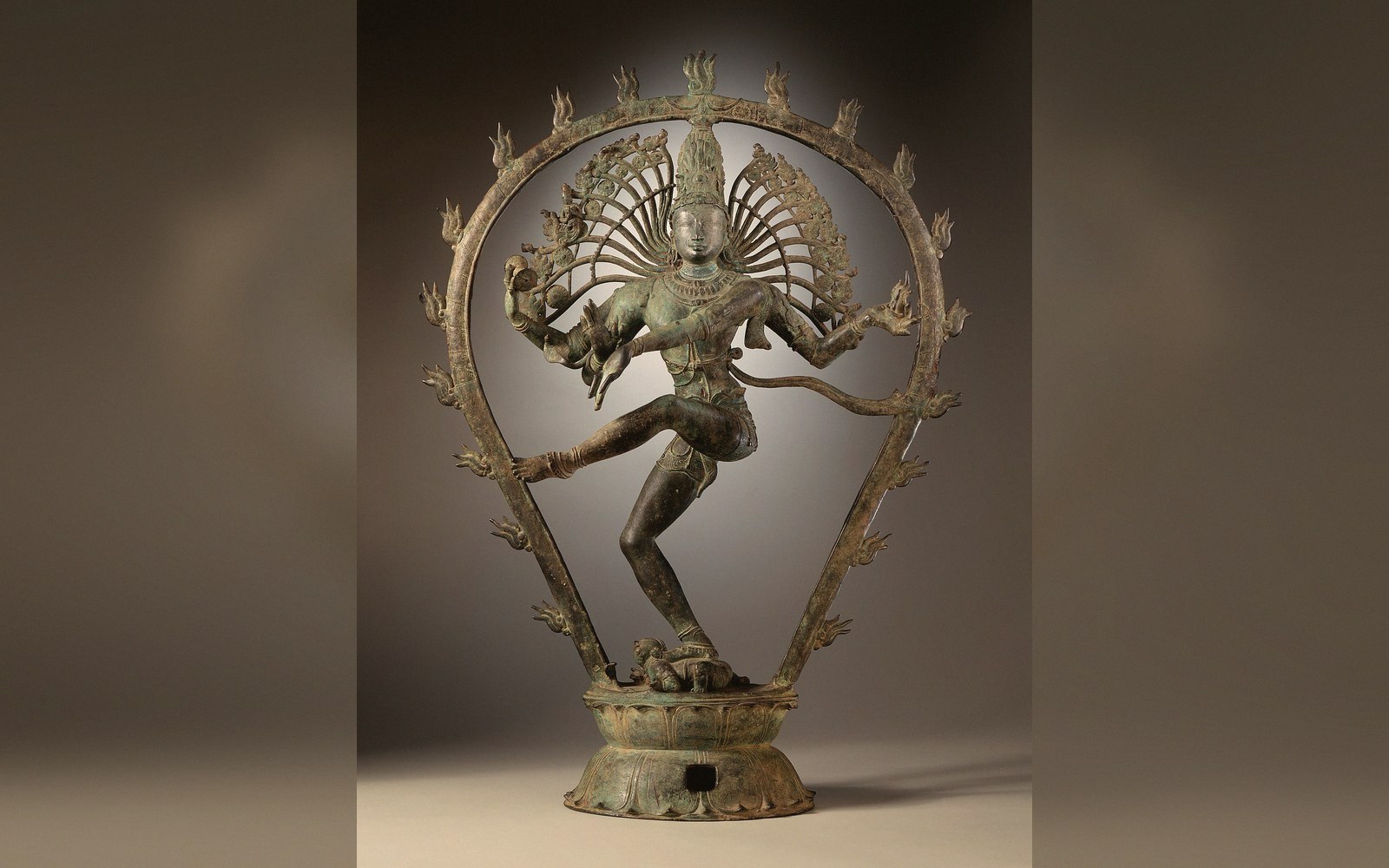 A bronze figure in the round on a plain mid-grey ground